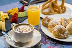 Disfrute del desayuno en el Hotel Paseo Del Arte, Madrid, con rico café, zumo de naranja natural, bollería variada, frutas vibrantes y churros crujientes. - ForTwo - Planes para parejas