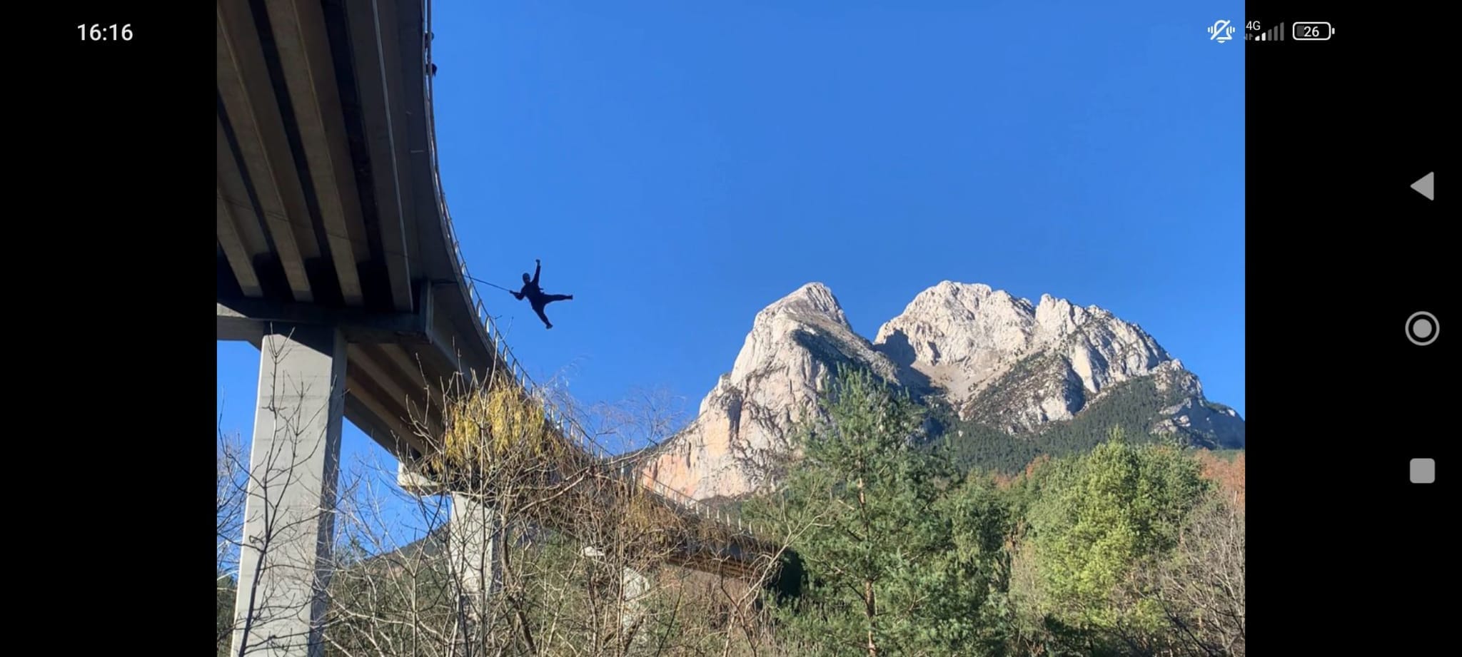 Un alma aventurera se sumerge en una experiencia de salto bungee tándem en Saldes, disfrutando del emocionante salto con el telón de fondo de majestuosas montañas y un cielo azul claro. - ForTwo - Planes para parejas
