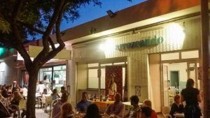 La cena al aire libre en el Restaurante Arrozeando (Málaga) es encantadora, y los comensales pueden disfrutar de sus comidas bajo las cálidas luces de la noche. - ForTwo - Planes para parejas