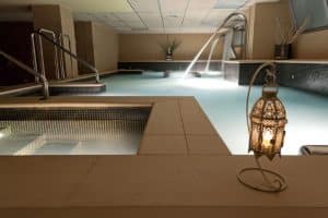 El Circuito Termal del Kumaras Spa en Umbrete ofrece una experiencia serena de 90 minutos con una iluminación suave, fuentes de agua relajantes y linternas que iluminan suavemente la piscina cubierta del spa. - ForTwo - Planes para parejas