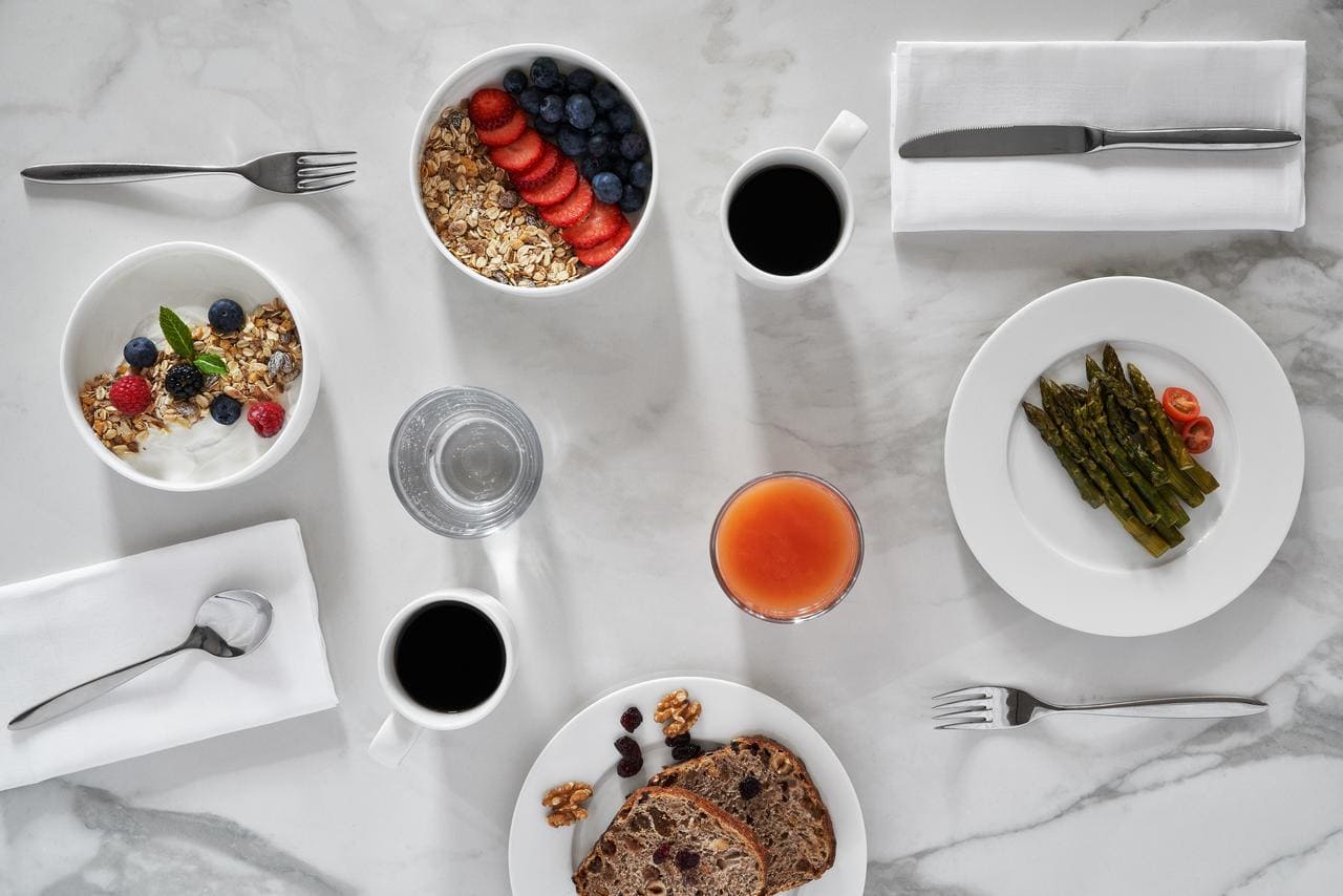 Una mesa de desayuno de mármol en el Hotel Arts (Barcelona) incluye granola, yogur, café, zumo, pan y espárragos. - ForTwo - Planes para parejas