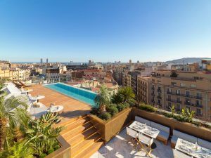 Descubra el oasis en la azotea del Hotel The One Barcelona GL con impresionantes vistas del skyline de Barcelona. Relájese junto a la piscina o cene bajo un cielo azul despejado, envuelto por la impresionante arquitectura de la ciudad. - ForTwo - Planes para parejas