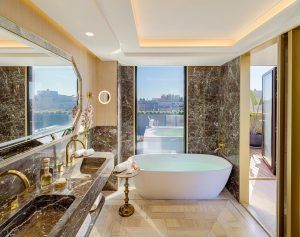 Disfrute del máximo lujo en el Hotel The One Barcelona GL, donde el baño cuenta con una bañera independiente, lavabo doble, detalles de mármol, un gran espejo y una ventana que da a un encantador balcón. - ForTwo - Planes para parejas
