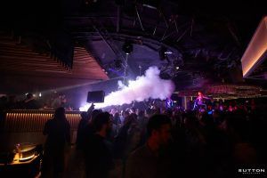 El Sutton Club Barcelona ofrece una vibrante escena nocturna con luces de colores, fascinantes efectos de humo y gente bailando, todo ello completamente inmerso en su atmósfera energética. - ForTwo - Planes para parejas