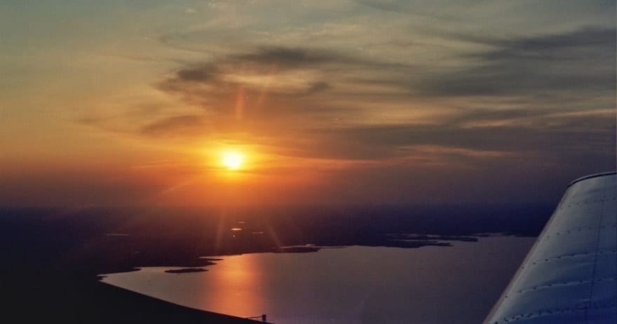 Disfrute de una impresionante vista del atardecer desde un vuelo de iniciación en avión por Montserrat (Barcelona), donde el cielo brilla sobre Montserrat y el lago de abajo brilla con reflejos. - ForTwo - Planes para parejas