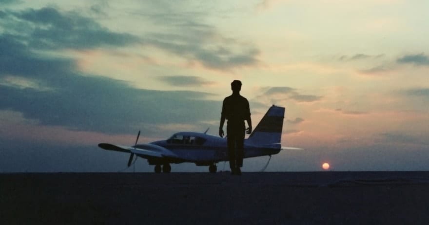 Una silueta camina hacia una avioneta al atardecer, contra el espectacular cielo de Montserrat en Barcelona durante un Vuelo de iniciación en avióneta. - ForTwo - Planes para parejas