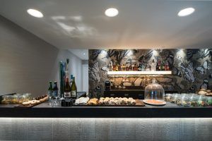 El Hotel Catalonia Magdalenes de Barcelona cuenta con un lujoso bar con un elegante mostrador que ofrece diversas bebidas, pasteles y aperitivos. - ForTwo - Planes para parejas
