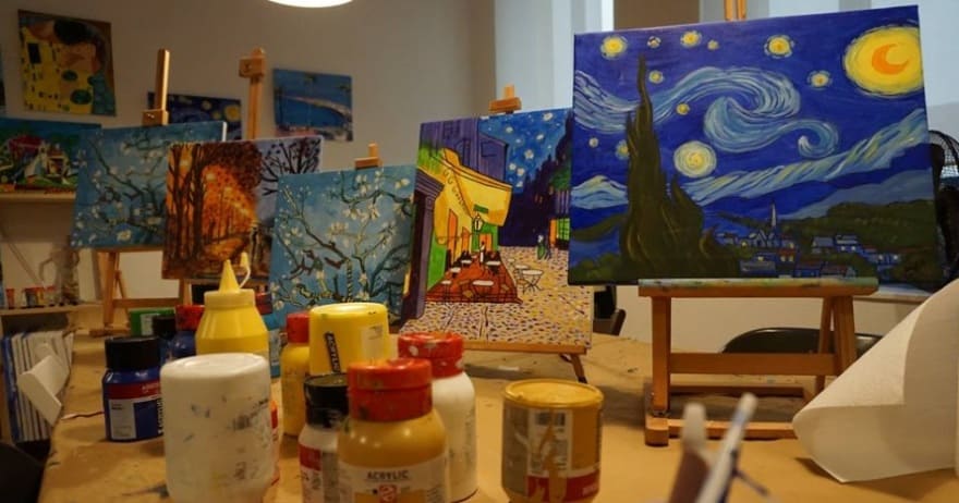 Estudio de arte en Madrid con pinturas en caballetes, incluida una réplica de La Noche Estrellada, rodeada de botellas de pintura, que ofrece un dinámico Taller creativo de pintura de cuadros para todos los entusiastas. - ForTwo - Planes para parejas