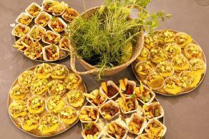 Los aperitivos dispuestos alrededor de una cesta de hierbas frescas recuerdan los sabores vibrantes de Taller de cocina en Sants con Taller 24 en Barcelona. - ForTwo - Planes para parejas