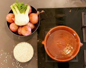 En la cocina del barrio de Sants, una clase de Taller de cocina en Sants con Taller 24 (Barcelona) llena el aire con aromas de hinojo, cebolla, arroz y una cazuela de barro hirviendo a fuego lento. - ForTwo - Planes para parejas