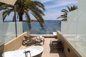 Relájese con estilo en el Hotel Torre del Mar (Ibiza) en nuestra terraza en la azotea, que cuenta con bañera, tumbonas y una impresionante vista al mar enmarcada por palmeras ondulantes. - ForTwo - Planes para parejas