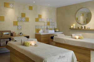 Relájese en el spa del Hotel Miramar Barcelona GL. Este remanso de paz cuenta con dos camillas de masaje, velas, azulejos decorativos e iluminación tenue que crean un ambiente cálido y relajante. Una escapada perfecta en el corazón de Barcelona. - ForTwo - Planes para parejas