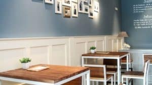La cafetería cuenta con muebles de madera, arte mural y plantas en macetas, con serenas paredes azules y blancas que evocan el ambiente del Restaurante Eustaquio Blanco en Cáceres. - ForTwo - Planes para parejas
