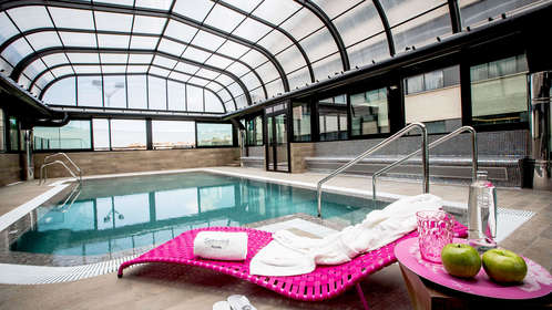 Experimente la relajación definitiva en el Sercotel Gran Luna, un hotel de 4* con piscina cubierta con techo abovedado de cristal. Relájese en una tumbona rosa con una toalla suave, manzanas crujientes y una bebida refrescante. Después, rejuvenezca en nuestro gimnasio y spa de última generación. - ForTwo - Planes para parejas