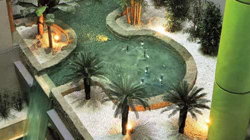 El hotel Sercotel Gran Luna 4* cuenta con un pequeño estanque interior iluminado con palmeras y caminos de piedra, creando una escapada tranquila en su lujoso spa y gimnasio de última generación. - ForTwo - Planes para parejas