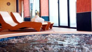 El Hotel Escapada Valles de Gredos + desayuno en Talayuela ofrece una moderna sala de spa con tumbonas de madera, toallas enrolladas y un jacuzzi burbujeante junto a amplios ventanales. Después del baño, disfrute de un delicioso desayuno para completar su estancia rejuvenecedora. - ForTwo - Planes para parejas