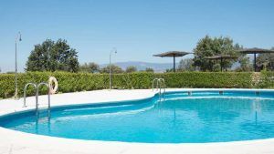 Ubicada en los Valles de Gredos, la piscina circular al aire libre del Escapada Hotel Valles de Gredos + desayuno (Talayuela) cuenta con elegantes escaleras de metal y está rodeada de frondosos árboles con majestuosas montañas como impresionante telón de fondo. - ForTwo - Planes para parejas