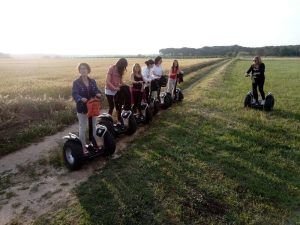 Un grupo recorre con gracia un camino de tierra en su Ruta en Segway por los arrozales de Pals, rodeado de extensos arrozales bajo un cielo despejado. - ForTwo - Planes para parejas