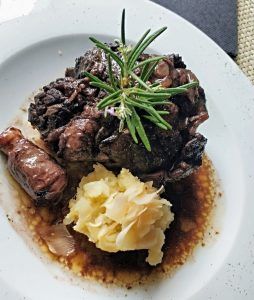 Un plato de carne estofada con guarnición de romero, que recuerda a una acogedora velada en la Almazara de San Pedro - Casa rural en Sierra de Gata con baño árabe, servido con puré de patatas y salsa. - ForTwo - Planes para parejas