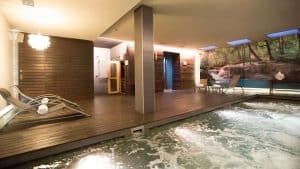 Experimente la tranquilidad en Escapada Hospes Palau de la Mar con desayuno y spa en Valencia, con un relajante jacuzzi, acogedoras tumbonas en una terraza de madera y una apacible sauna. El papel pintado con motivos naturales invita a la relajación: un refugio perfecto antes del desayuno. - ForTwo - Planes para parejas