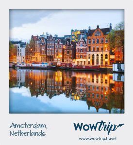 Las coloridas casas de los canales de Ámsterdam que se reflejan en el agua al anochecer ofrecen una vista pintoresca, que recuerda una estancia encantadora con el "Viaje sorpresa con vuelo + hotel a una ciudad de Europa". - ForTwo - Planes para parejas