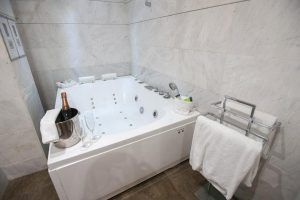 Experimente el lujo en el Hotel Silken Puerta de Valencia con una bañera de hidromasaje de mármol, champán y copas de cortesía y suaves toallas para una estancia inolvidable. - ForTwo - Planes para parejas