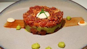 En el Restaurante Galipán de Valencia, disfrute de una versión única del tartar de atún con aguacate, cubierto con alioli y cebollino, bellamente servido en un plato decorativo. - ForTwo - Planes para parejas