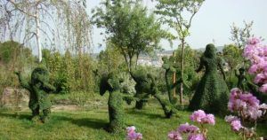 Explora El Bosque Encantado cerca de Madrid, donde los bailarines de topiario están enmarcados por árboles y flores rosadas. Disfruta de un día mágico con entradas rebajadas utilizando "Entradas con descuento para El Bosque Encantado (Madrid). - ForTwo - Planes para parejas