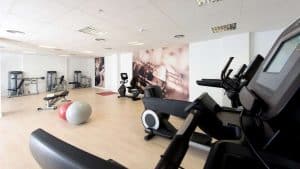 El Hotel Náutico Ebeso en Ibiza ofrece un moderno gimnasio con cintas de correr, bicicletas estáticas, una máquina de pesas y dos pelotas de fitness sobre un elegante suelo de madera. - ForTwo - Planes para parejas