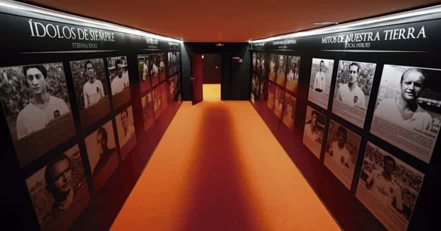 En el Mestalla Forever Tour, las paredes de los pasillos muestran fotografías y textos en blanco y negro que muestran a los jugadores de fútbol, complementados con un piso naranja único, que ofrece una experiencia inmersiva en el icónico estadio de Valencia. - ForTwo - Planes para parejas