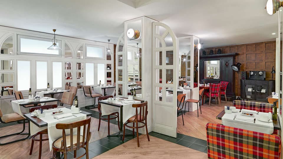 El hotel Escapada H10 Montcada con extras (Barcelona) ofrece un ambiente cálido y acogedor, con un acogedor interior de restaurante con mesas de madera, sillas a cuadros y mamparas blancas. - ForTwo - Planes para parejas
