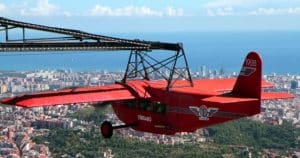 Las "Entradas para el parque de atracciones Tibidabo (Barcelona)" ofrecen un paseo en un vibrante teleférico rojo que se desliza sobre la ciudad, proporcionando impresionantes vistas de la costa y del cautivador Tibidabo. - ForTwo - Planes para parejas