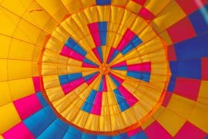 Vista interior de un globo vibrante, que muestra patrones concéntricos en amarillo, azul, rosa y naranja: una instantánea vívida durante un Vuelo estándar en globo por Cataluña con Globus (Barcelona) sobre los impresionantes paisajes de Cataluña. - ForTwo - Planes para parejas