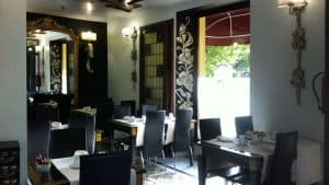Disfrute de una cena en un elegante restaurante que evoca una casa del siglo XVIII, con espejos decorativos, sillas negras, manteles blancos y exquisitas obras de arte en las paredes. Disfrute de la luminosa vista desde la ventana para una escapada perfecta con desayuno y botella de cava en Sevilla. - ForTwo - Planes para parejas
