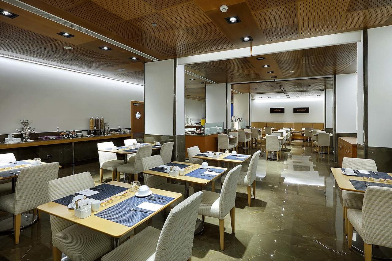 El Hotel Eurostars Gran Valencia le recibe con un moderno restaurante con mesas cuidadosamente dispuestas, techo de madera y suelo de baldosas brillantes. - ForTwo - Planes para parejas