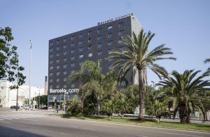 El elegante y moderno Hotel Barceló (Valencia) se alza orgulloso entre palmeras ondulantes en un día soleado. - ForTwo - Planes para parejas