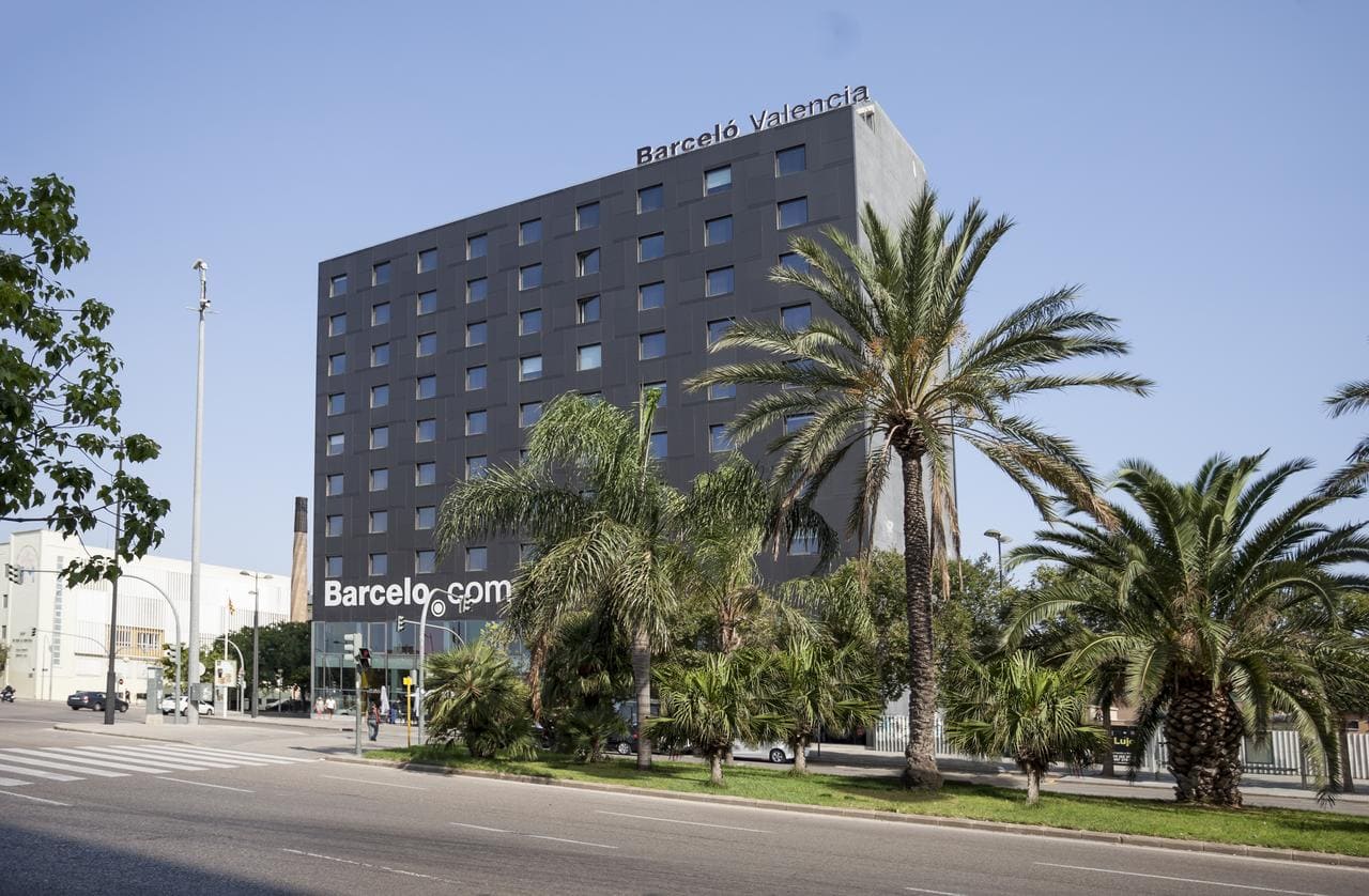 El elegante y moderno Hotel Barceló (Valencia) se alza orgulloso entre palmeras ondulantes en un día soleado. - ForTwo - Planes para parejas