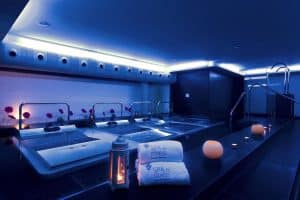 El spa del Hotel Barceló Valencia, con una iluminación tenue, cuenta con velas, flores y toallas de marca para crear un ambiente sereno. Sus múltiples jacuzzis invitan a relajarse en este tranquilo refugio en el centro de la ciudad. - ForTwo - Planes para parejas