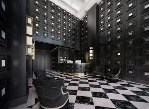 El elegante vestíbulo del Hotel NH Collection Colón (Valencia) luce paredes oscuras, un suelo estampado y un mostrador de recepción curvo, realzado por elegantes asientos. - ForTwo - Planes para parejas