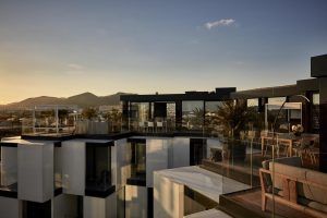 Experimente el encanto moderno de una terraza en la azotea de Ibiza en el Sir Joan Hotel, con elegantes barandillas de vidrio, elegantes muebles de exterior e impresionantes vistas del atardecer sobre las montañas. - ForTwo - Planes para parejas