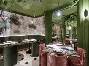 Purnima en Madrid ofrece una elegante experiencia gastronómica con paredes verdes, exuberante follaje, asientos de terciopelo y mesas elegantes, perfectas para disfrutar de la exquisita cocina india con su Menú degustación. - ForTwo - Planes para parejas