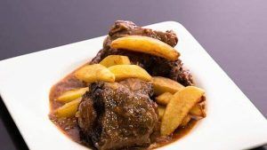 Saborea la "Oferta: cena para dos en Bodegas Mezquita, menú especial Mezquita (Córdoba)" con carne guisada con salsa y papas fritas gruesas en un plato cuadrado blanco, inspirada en los sabores cordobeses. Disfrute de esta memorable experiencia gastronómica en Bodegas Mezquita. - ForTwo - Planes para parejas