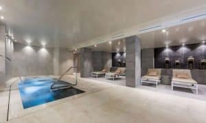 Descubra la elegancia de nuestro moderno spa interior en Granada, con piscina rectangular, tumbonas e iluminación tenue. Disfrute de un ambiente tranquilo y mejore su visita con nuestro Circuito de spa con masajes en pareja para una experiencia serena. - ForTwo - Planes para parejas