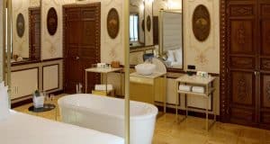 Disfrute de una escapada de lujo en la suite Preciosa del Hotel Axel - Adults Only (Madrid), que cuenta con una bañera independiente blanca, puertas de madera ornamentadas, espejos y una decoración elegante. - ForTwo - Planes para parejas