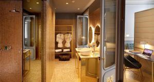 Lujoso baño solo para adultos con detalles dorados, suaves albornoces y un gran espejo. Descubra la elegancia en la Suite Preciosa del Hotel Axel Madrid, con un escritorio y un práctico espacio para portátil. - ForTwo - Planes para parejas