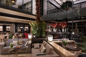 Descubra el lujoso salón del hotel Meliá Castilla (Madrid), con muebles modernos, asientos acogedores, plantas exuberantes e iluminación cálida: una exquisita extensión de la elegancia de su Suite presidencial en el hotel Meliá Castilla (Madrid). - ForTwo - Planes para parejas