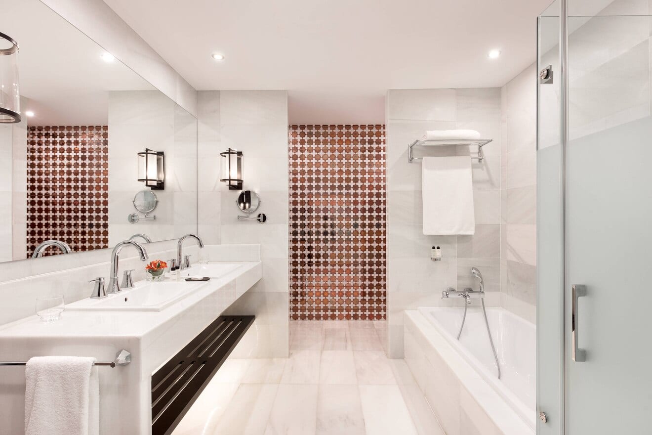Disfrute del lujo en la Suite Deluxe, donde un moderno baño con lavabos dobles y paredes con espejo se combina con la elegancia que recuerda al Hotel Alfonso XIII de Sevilla, Máxima Elegancia en la Suite Deluxe. - ForTwo - Planes para parejas