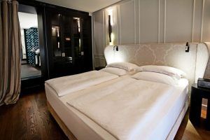 Disfrute de una estancia elegante en el Hotel Palacio de Villapanés, Sevilla. Nuestras suites únicas cuentan con cama king size, suelo de madera y vistas a un moderno baño con paredes estampadas, perfectas para una estancia inolvidable. - ForTwo - Planes para parejas