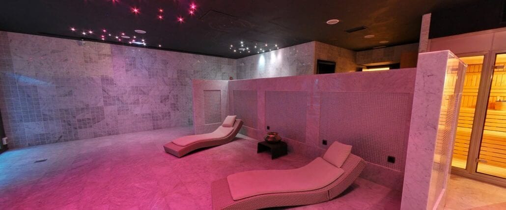 Experimente el tranquilo oasis del salón Spa en el Hotel Palacio De Villapanés en Sevilla, que cuenta con dos tumbonas, iluminación ambiental rosa, luces de techo estrelladas y una sauna de madera, como parte de nuestra experiencia Suites únicas en el Hotel Palacio De Villapanés. - ForTwo - Planes para parejas