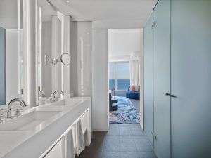 Experimente la elegancia de un baño moderno en la Cool Corner Suite: el mar a tus pies en W Hotel (Barcelona), que cuenta con dos lavabos, grandes espejos, una ducha de cristal y vistas impresionantes al mar desde su sala de estar privada. - ForTwo - Planes para parejas